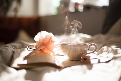 书上的茶杯放在粉色花饰旁边